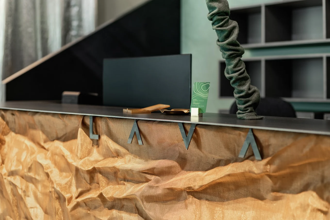 LAVA Dental Studio reception desk — the LAVA mark in gold